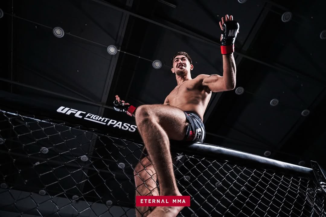 Kourosh Arvan celebrates on top of the cage